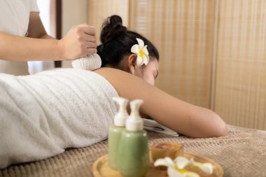 Güzel genç Asyalı kadın spa ortamında masaj yaptırıyor, geleneksel aromaterapi ve güzellik terapisi, yakın plan fotoğraf..