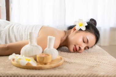Güzel genç Asyalı kadın spa ortamında masaj yaptırıyor, geleneksel aromaterapi ve güzellik terapisi, yakın plan fotoğraf..