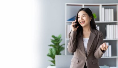 Genç Asyalı iş kadını telefonda konuşuyor. Yeni açılan bir şirkette satış elemanı. Ürün ve promosyon satmak için müşterileri arıyor. finansal muhasebe kavramı