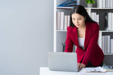 İşkadını, iş ofisindeki ahşap masa, istatistik ve analitik araştırma konsepti, muhasebe ve vergi konularında finansal matematik yapmak için dizüstü bilgisayar kullanıyor.