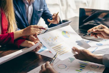 Finansal raporlarda satış analizlerini tartışmak için çalışma arkadaşlarıyla buluş. Şirket pazarlama raporlarında satış analiziyle ilgili mali muhasebe ve iş stratejisi planlaması.