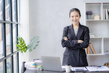 İş planlama ofisinde çalışan profesyonel Asyalı kadın muhasebeci muhasebe satış raporlarını gözden geçiriyor. Bilgisayarda çalışan finans analisti, online iş kavramı.