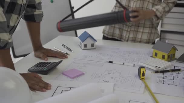 工程师讨论平面建筑工程建筑师站在一张大桌子旁边 在村里建的一间办公室里那个承包商工人和建筑商核对一下 工程师和工头质量控制 — 图库视频影像