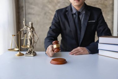 Hukuk ve adalet kavramı. Çekiç ve altın pullarla çalışan genç erkek avukat. Asyalı hukuk danışmanı.