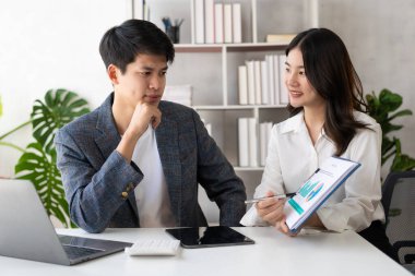 Başarılı bir Asyalı iş adamı ve kadın birlikte çalışarak ev kurma konsepti, takım çalışması, çift, erkek ve kadın iş projesi ve yatırım konularını tartışıyor..