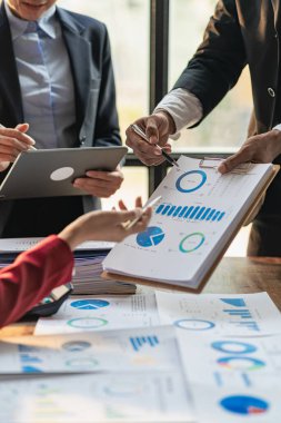 Hesap makinesi kullanarak iş ekibi toplantısı. Çizelgelerle çalış ve iş stratejilerini analiz et. finansal istatistikler masadaki dikey görünümde oturuyor