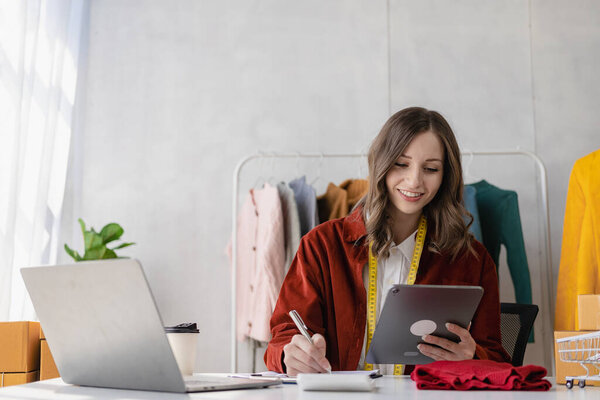 Красивая блоггер показывает одежду перед камерой смартфона во время записи видео, видеосъемки и прямой трансляции в ее магазине, бизнес-концепции МСП, интернет-магазинов.