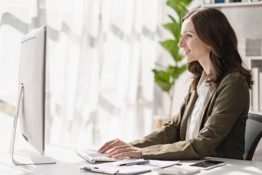 Finansal matematik analitik araştırma konsepti için evrak hazırlarken dizüstü bilgisayar kullanan başarılı bir iş kadını