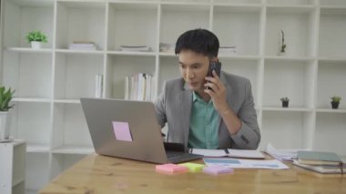 Finansal grafik dokümanı ve akıllı telefonu sohbet kuryesi uygulaması kullanarak elinde tutan serbest bilgisayar yöneticisiyle masa başında çalışan bir iş adamı. Kariyer VIDEO 4k