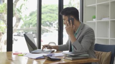 Finansal grafik dokümanı ve akıllı telefonu sohbet kuryesi uygulaması kullanarak elinde tutan serbest bilgisayar yöneticisiyle masa başında çalışan bir iş adamı. Kariyer VIDEO 4k