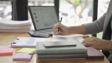 Ofiste çalışan Asyalı erkek işadamı bilgisayarınızı ve hesap makinenizi kullanarak mali raporları hesaplıyor. Finansal muhasebe kavramında