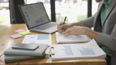Ofiste çalışan Asyalı erkek işadamı bilgisayarınızı ve hesap makinenizi kullanarak mali raporları hesaplıyor. Finansal muhasebe kavramında