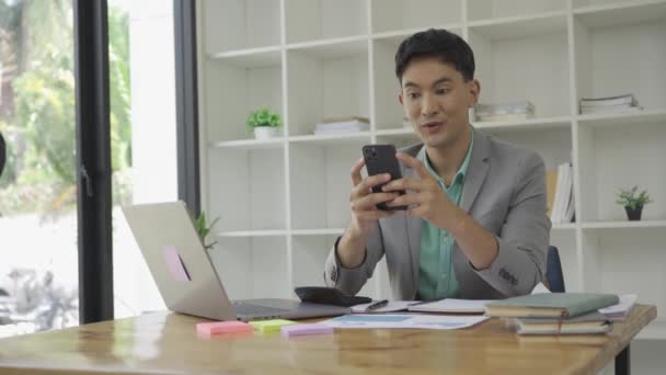 비즈니스 사무실에서 그래프 문서와 메신저 사용하여 스마트폰을 프리랜서 매니저와 일한다 — 비디오