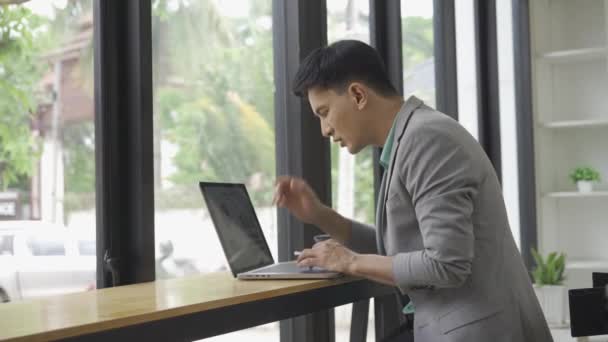 オフィスで働くアジアの男性ビジネスマンは 財務報告を計算しますあなたのラップトップと計算機を援助として使用して文書を管理します 財務会計の概念では — ストック動画