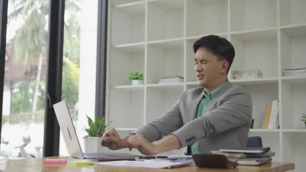 亚洲商人坐在笔记本电脑上 患有办公室综合症 背痛和肩痛 试着伸出手来缓解手腕疼痛 工作时间太长了 — 图库视频影像