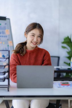 Ofiste dizüstü bilgisayarda çalışan genç bir kadın, iş yerinde çalışan Asyalı bir muhasebeci, evde finansal belgelerle çalışan güzel serbest çalışan bir kız. dikey resim