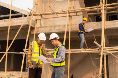 İnşaat mühendisleri, yönetim ekibiyle iletişim kurmak için telsiz kayıtlarını inceliyor. Mühendis, inşaat alanındaki inşaat fikirlerini denetlemesi için ev yapımını önerdi.