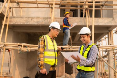 İnşaat mühendisleri, yönetim ekibiyle iletişim kurmak için telsiz kayıtlarını inceliyor. Mühendis, inşaat alanındaki inşaat fikirlerini denetlemesi için ev yapımını önerdi.