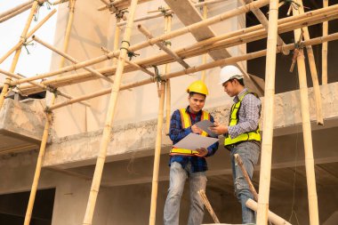 İnşaat mühendisleri, yönetim ekibiyle iletişim kurmak için telsiz kayıtlarını inceliyor. Mühendis, inşaat alanındaki inşaat fikirlerini denetlemesi için ev yapımını önerdi.