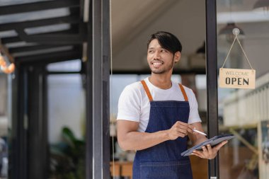 Açık tabelalı önlük takan zenci bir esnaf kafenin girişinde durup yemek yiyor. Başarılı başlangıç ve yeni mağaza konsepti