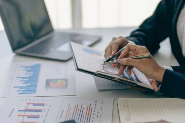 İş kadını ellerinin kalemini kapayarak finansal dökümanlara işaret ederek finansal planlama finansal raporlama iş yatırım konsepti ile ilgili belgelerle analiz edilir.