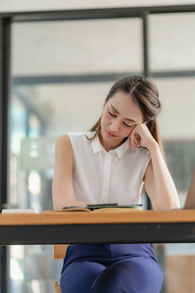 Мысль азиатской бизнес-женщины, глядя на финансовые отчеты и составление маркетингового плана с помощью компьютера на своем столе в офисе, держа отчет документы девушка чтение финансовой информации