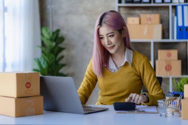 Çevrimiçi alışveriş için teslimat kutuları hazırlayan Asyalı kadın yeni başlayanlar küçük işletme sahiplerine evde, KOBİ 'nin internet üzerinden alışveriş gibi fikirlerinde başladılar.