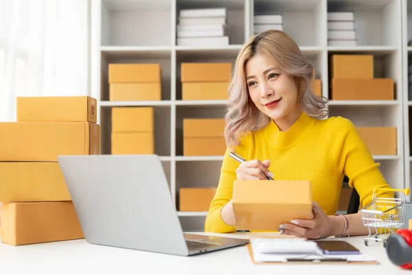 Asian woman preparing delivery boxes for online shopping Beginners start small business owners at home, SME business ideas like online shopping.