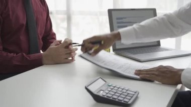 Ev alıcıları bir emlakçıyla ev kiralama ya da satın alma konusunda ve ev satın alma anlaşmasının şartları hakkında görüşür ve müşteriden satışı tamamlamak için evrakları imzalamasını isterler..