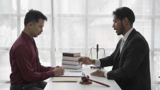 スケールと裁判官のハンマーとテーブルに座って法的問題に若いアジアのビジネスマンのコンサルティング弁護士をストレス — ストック動画