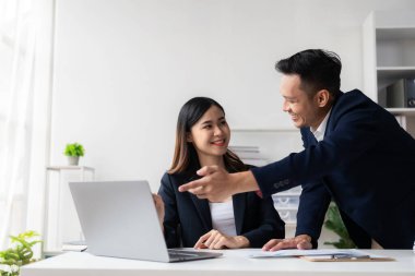 Zeki ve profesyonel erkek yönetici, bayan asistanıyla çalışıyor. Mali raporları grafik kağıtları ve masaüstü bilgisayarlarla analiz et.