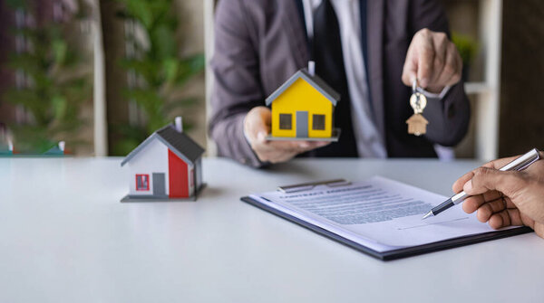 The home broker recommends the client to sign the contract,Real estate concept.Real estate agents are recommending to provide information about housing to customers. Buy house, real estate concept.