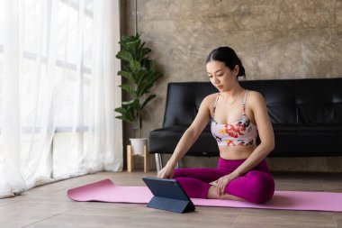 Genç Asyalı kadın sabahları yatak odasında yoga yapıyor. Evde yoga yaparak nefes alan ve meditasyon yapan sağlıklı genç bir kadın.