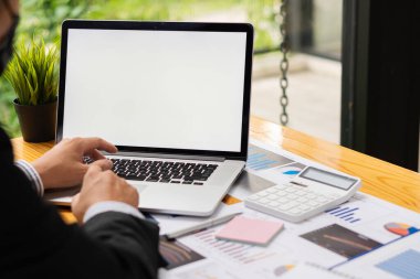 Ofiste dizüstü bilgisayarla çalışan genç bir finans analisti. Masasında oturup belgeleri inceleyen bir iş adamı. Fotoğrafları kapatıyor.