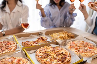 Üç Asyalı kız öğle yemeği vakti evde eğlenceli bir pizza partisi veriyor..