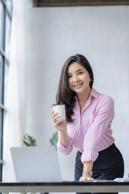 Dizüstü bilgisayarda çalışan Asyalı kadın muhasebeci ve yatırımla ilgili sonuçları gösteren mali grafikler. Başarılı bir iş büyüme süreci planlayın. dikey resim