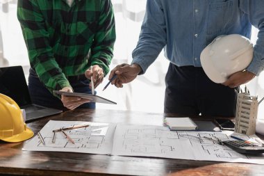 Ev tasarımı mimarı, müşteriye özel projeleri inceler ve teslimat mühendisinin ofisinden önceki modele göre mimari planlar, inşaat projeleri, iş inşaatı için saha teftişi