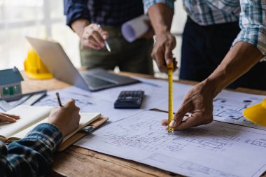 Ev tasarımı mimarı, müşteriye özel projeleri inceler ve teslimat mühendisinin ofisinden önceki modele göre mimari planlar, inşaat projeleri, iş inşaatı için saha teftişi
