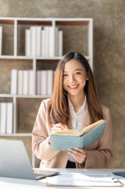 Masa, vergi, rapor, muhasebe, istatistik ve finansal grafik analizi kavramında matematiksel finans için dizüstü bilgisayar kullanan Asyalı kadın. dikey resim