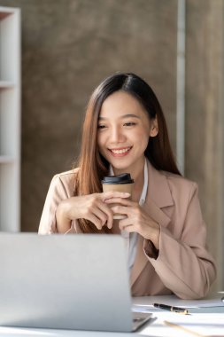 Masa, vergi, rapor, muhasebe, istatistik ve finansal grafik analizi kavramında matematiksel finans için dizüstü bilgisayar kullanan Asyalı kadın. dikey resim