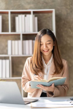 Masa, vergi, rapor, muhasebe, istatistik ve finansal grafik analizi kavramında matematiksel finans için dizüstü bilgisayar kullanan Asyalı kadın. dikey resim