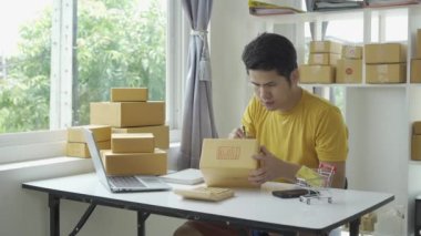Evde kutu ve dizüstü bilgisayarla internet satan Asyalı genç adam müşterilerden emir alıyor, KOBİ işiyle ilgili kavram