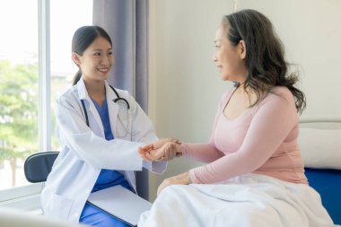 60 yaşında Asyalı bir kadınla birlikte genç bir bakıcı tavsiye ve teşvik veriyor. Bir geçmiş alın ve klinikte mutlu bir şekilde yaşamak için uygun bir tedavi önerin..