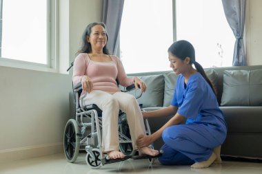 Asyalı kadın fizyoterapist yaşlı kadının bacak kaslarını esnetmesine ve spor salonu sağlık konseptinde bacak veya bacak rehabilitasyonu yapmasına yardım ediyor.