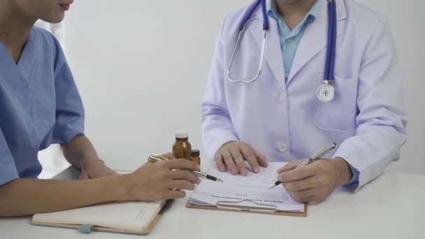 Paciente Asiática Sentada Una Mesa Escuchando Profesional Médico Con Estetoscopio — Vídeos de Stock
