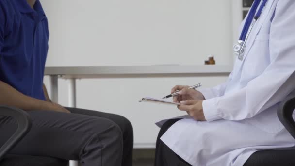 남자가 검사를 아시아 의사와 상담하고 의사는 환자의 질병에 건강에 조언을 — 비디오
