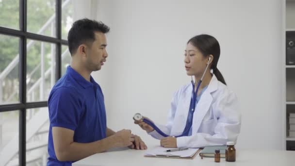 医生用听诊器检查病人的呼吸速率或脉搏速率 亚洲男人用听诊器检查病人的健康状况 而女医生用听诊器检查病人的心率 — 图库视频影像