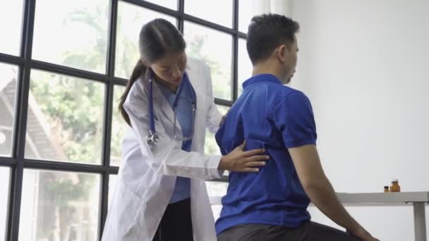 Vrouwelijke Arts Geeft Mannelijke Patiënt Fysiotherapie Met Hand Lift Aziatische — Stockvideo