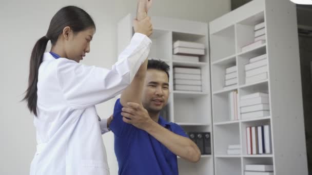 Kvinnlig Läkare Som Ger Manliga Patienter Sjukgymnastik Med Handlyft Asiatisk — Stockvideo