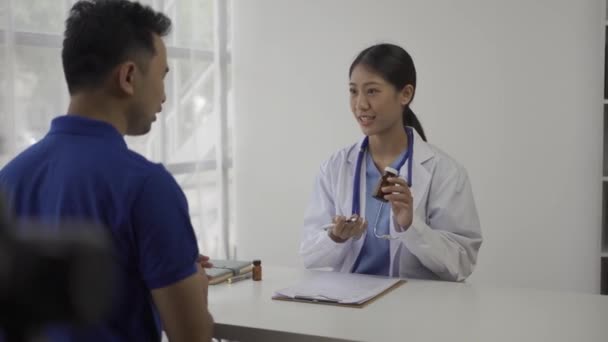 Bonito Jovem Asiático Médico Feminino Dando Conselhos Para Paciente Masculino — Vídeo de Stock